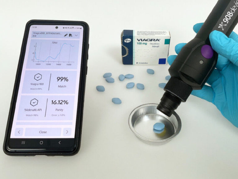 Handheld NIR device scanning a pharmaceutical tablet to verify its authenticity