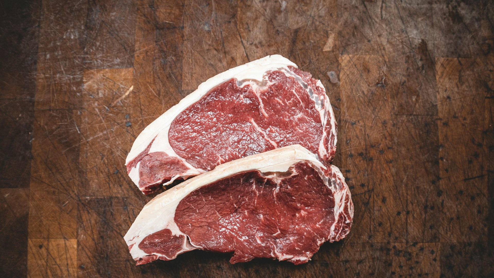 Beef steaks on a wooden butcher block